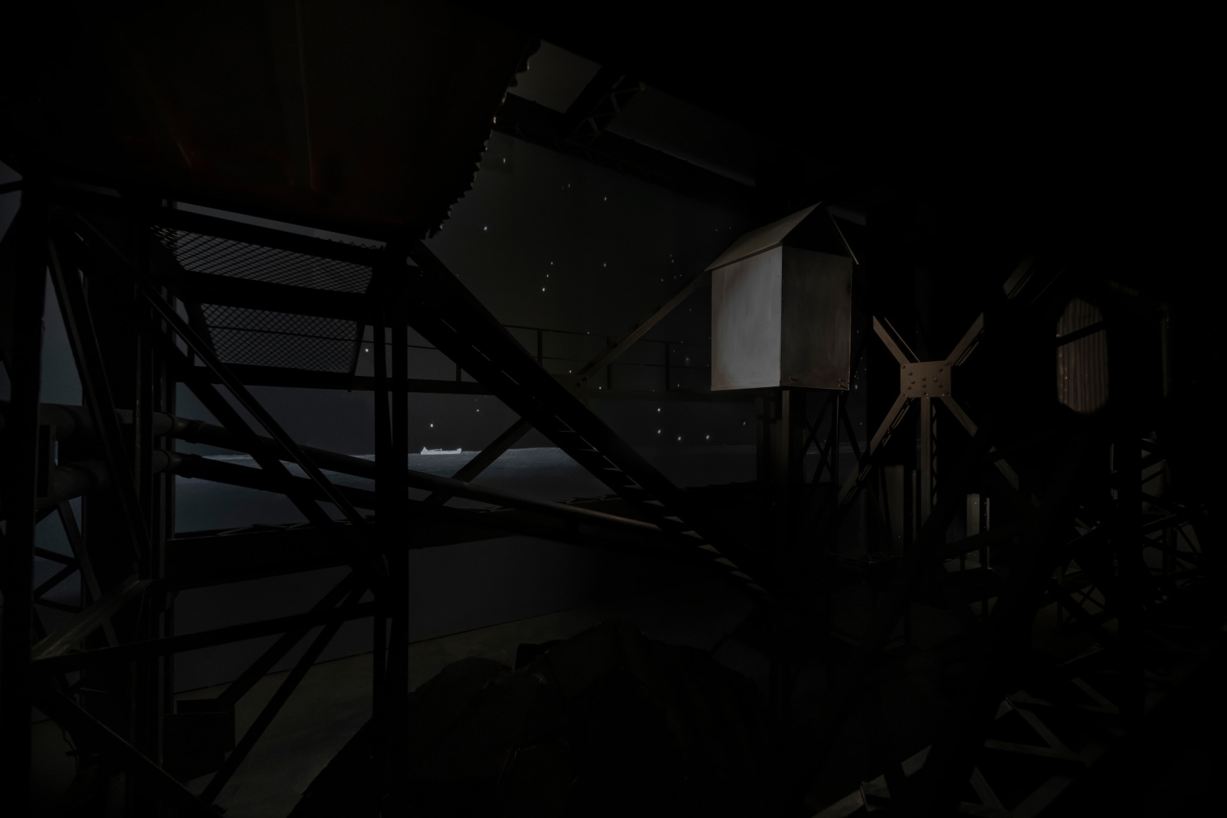 Ship/Dock/Three Houses and the Night Sky, 2023, Wood, plastic, glass, acrylic paint, electrical fixtures, metal, video projections, sound, darkness, 12’ x 29’9” x 14’9”