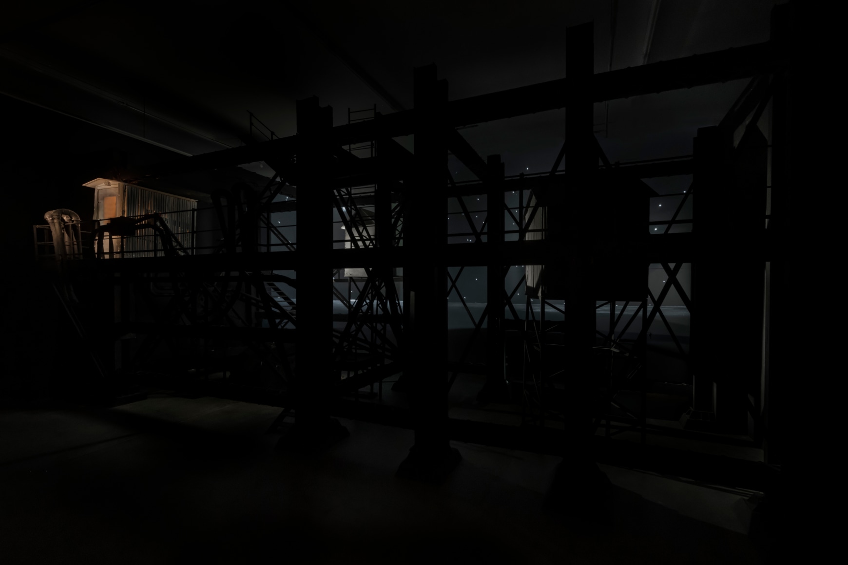 Ship/Dock/Three Houses and the Night Sky, 2023, Wood, plastic, glass, acrylic paint, electrical fixtures, metal, video projections, sound, darkness, 12’ x 29’9” x 14’9”