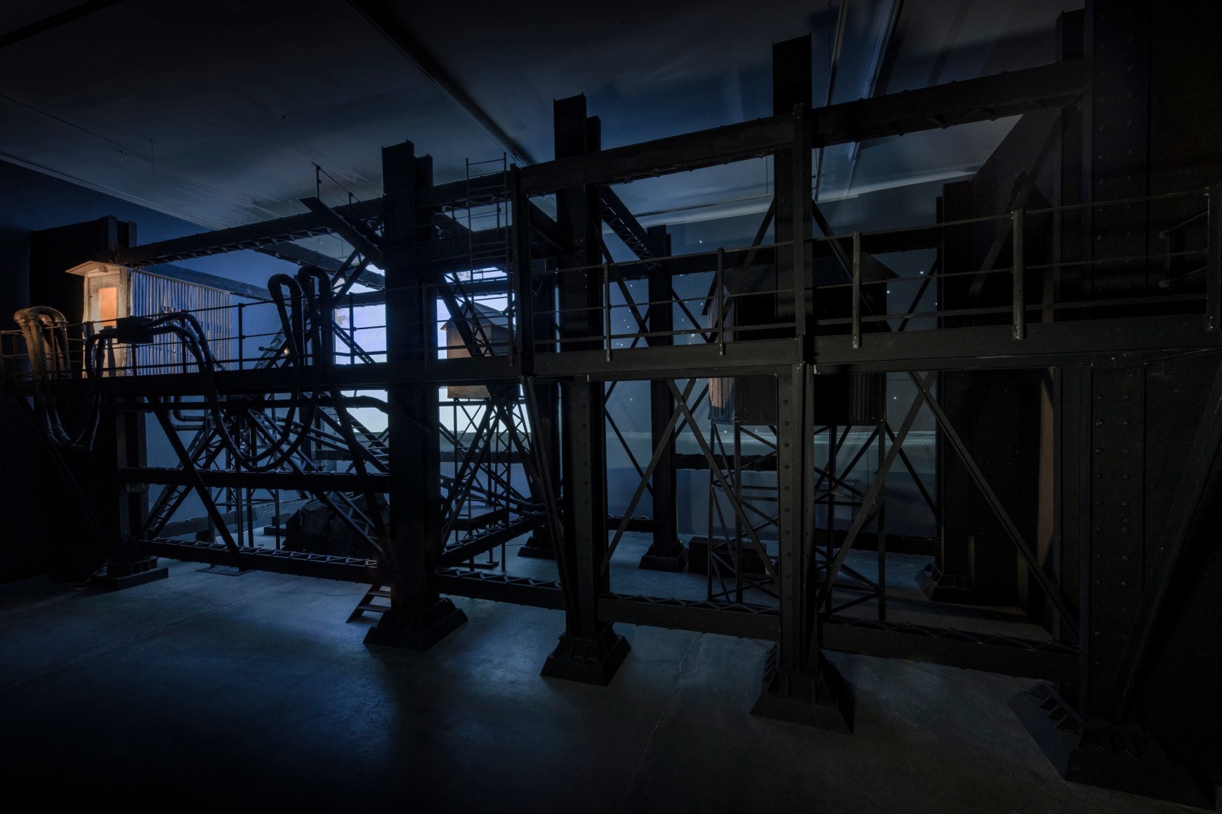 Ship/Dock/Three Houses and the Night Sky, 2023, Wood, plastic, glass, acrylic paint, electrical fixtures, metal, video projections, sound, darkness, 12’ x 29’9” x 14’9”
