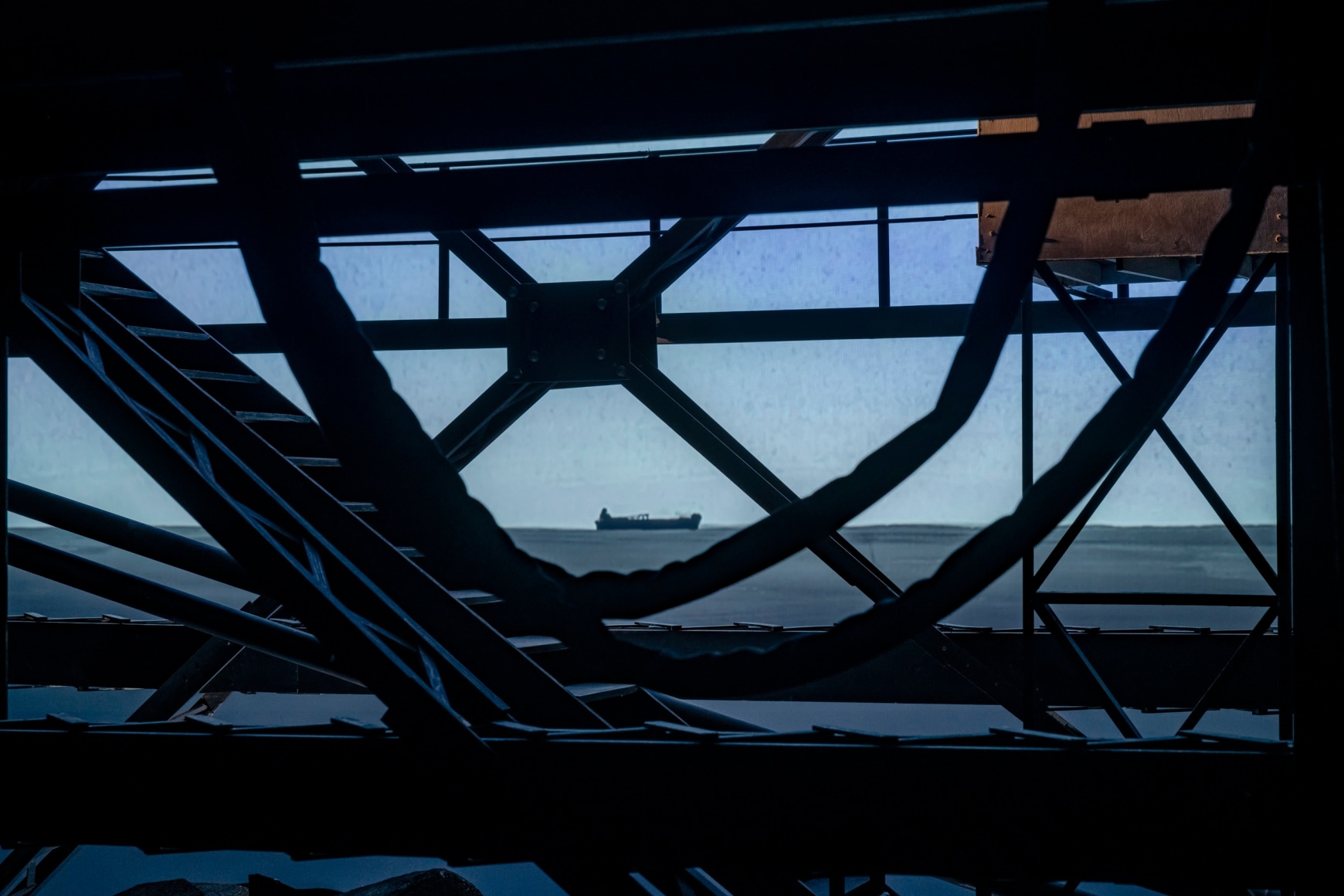 Ship/Dock/Three Houses and the Night Sky, 2023, Wood, plastic, glass, acrylic paint, electrical fixtures, metal, video projections, sound, darkness, 12’ x 29’9” x 14’9”