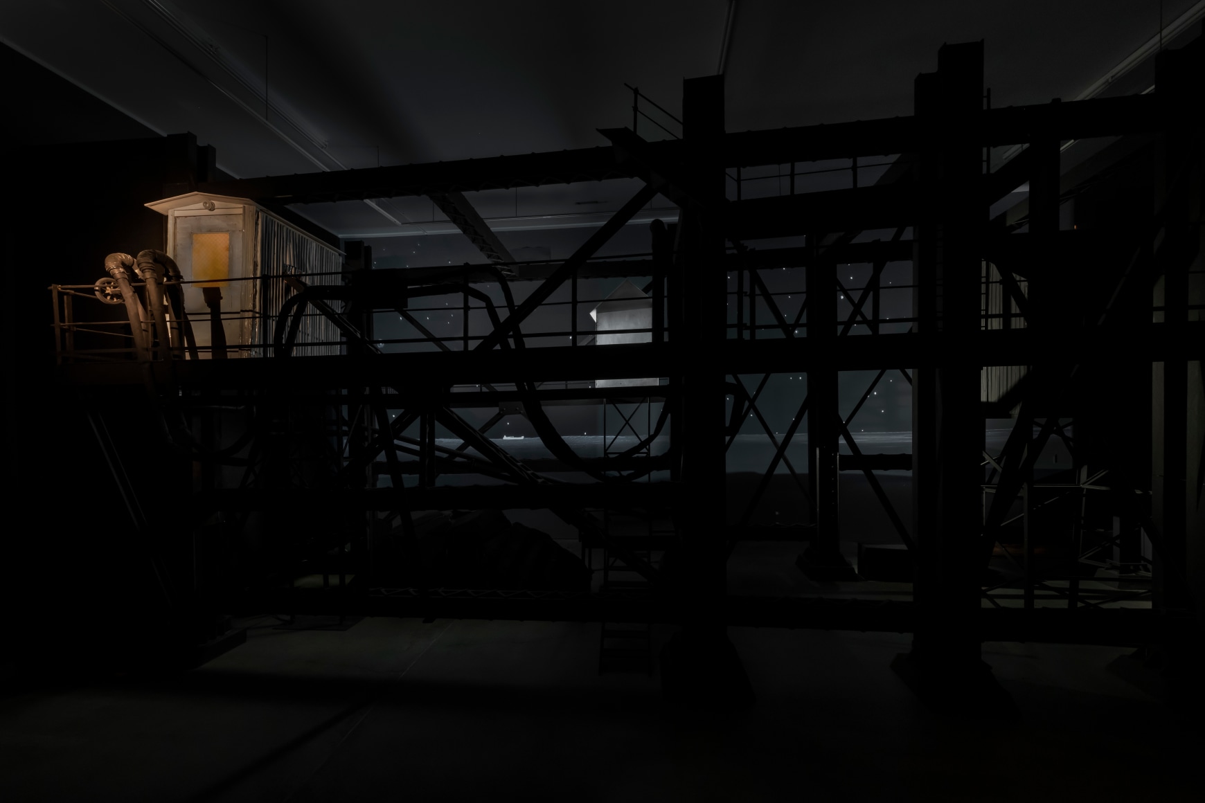 Ship/Dock/Three Houses and the Night Sky, 2023, Wood, plastic, glass, acrylic paint, electrical fixtures, metal, video projections, sound, darkness, 12’ x 29’9” x 14’9”