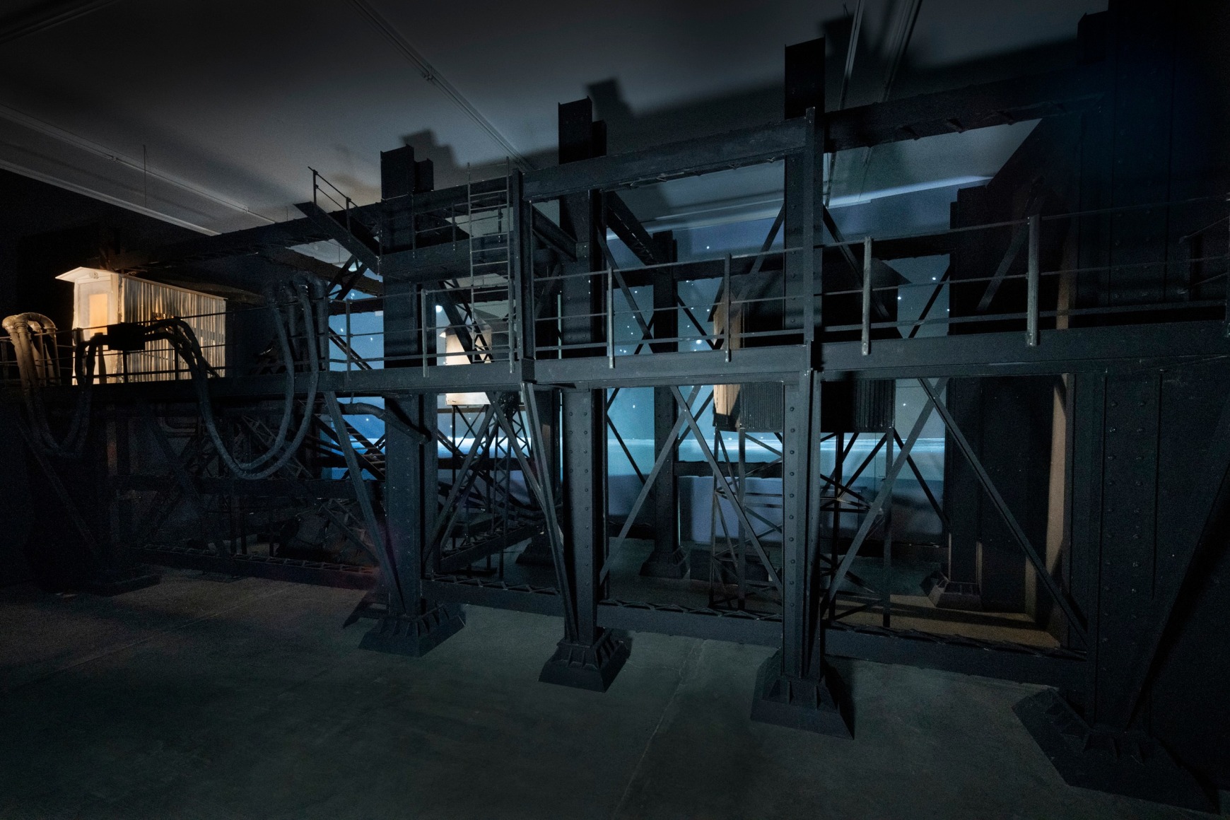 Ship/Dock/Three Houses and the Night Sky, 2023, Wood, plastic, glass, acrylic paint, electrical fixtures, metal, video projections, sound, darkness, 12’ x 29’9” x 14’9”