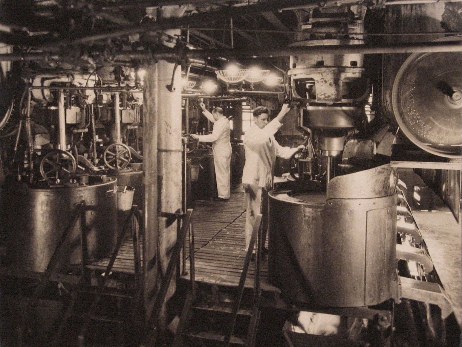 Harold Haliday Costain, Edgewater, NJ Sugar Refinery, ​1935. Two men in white operate machinery.