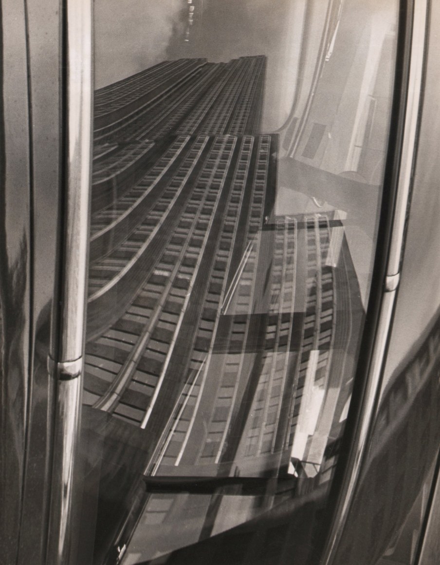 28. Fritz Neugass, Empire State Building Reflection, ​c. 1948. Distorted reflection view of the Empire State Building's base, looking upward.