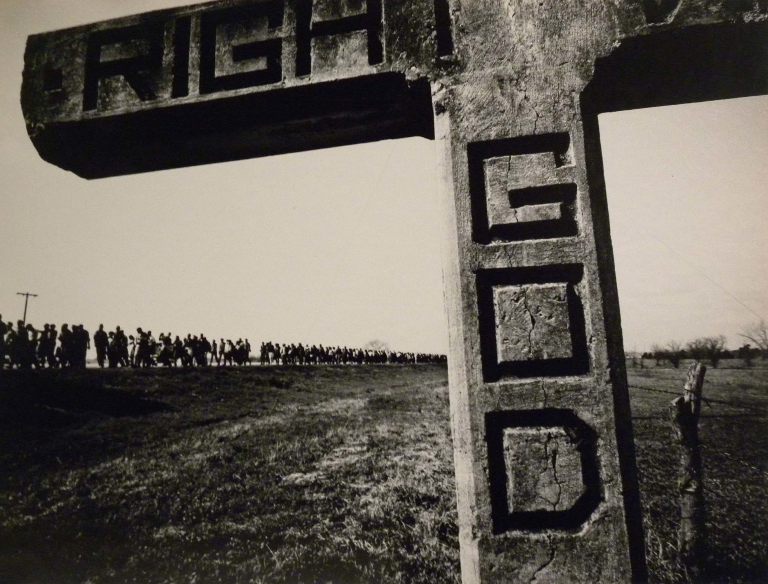36. James Karales, &quot;Get Right with God&quot; sign on Highway 80 on the Selma to Montgomery March, ​1964. Sign is in the shape of a cross in the foreground; a long procession of marchers in the background.