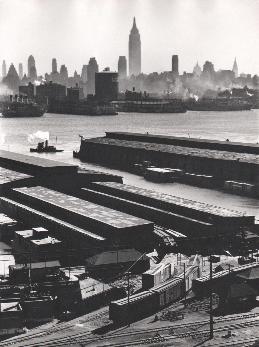 20. Esther Bubley, Weehawken, New Jersey. View looking east from 50th Street and East Boulevard showing New York Central piers, Hudson River and Midtown Manhattan skyline, 1946.