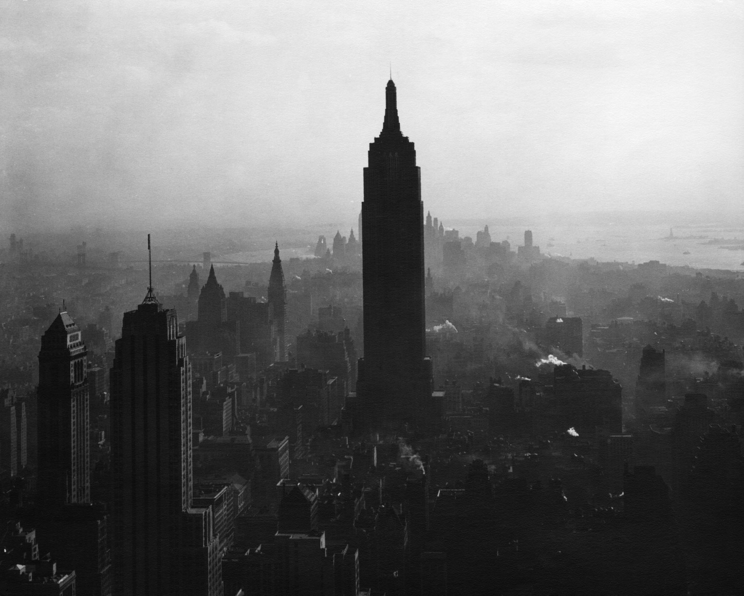38. Todd Webb, View South from the top of the RCA Building showing the Empire State Building, ​1947. Elevated view of the silhouetted Empire State and surrounding buildings amidst light fog.