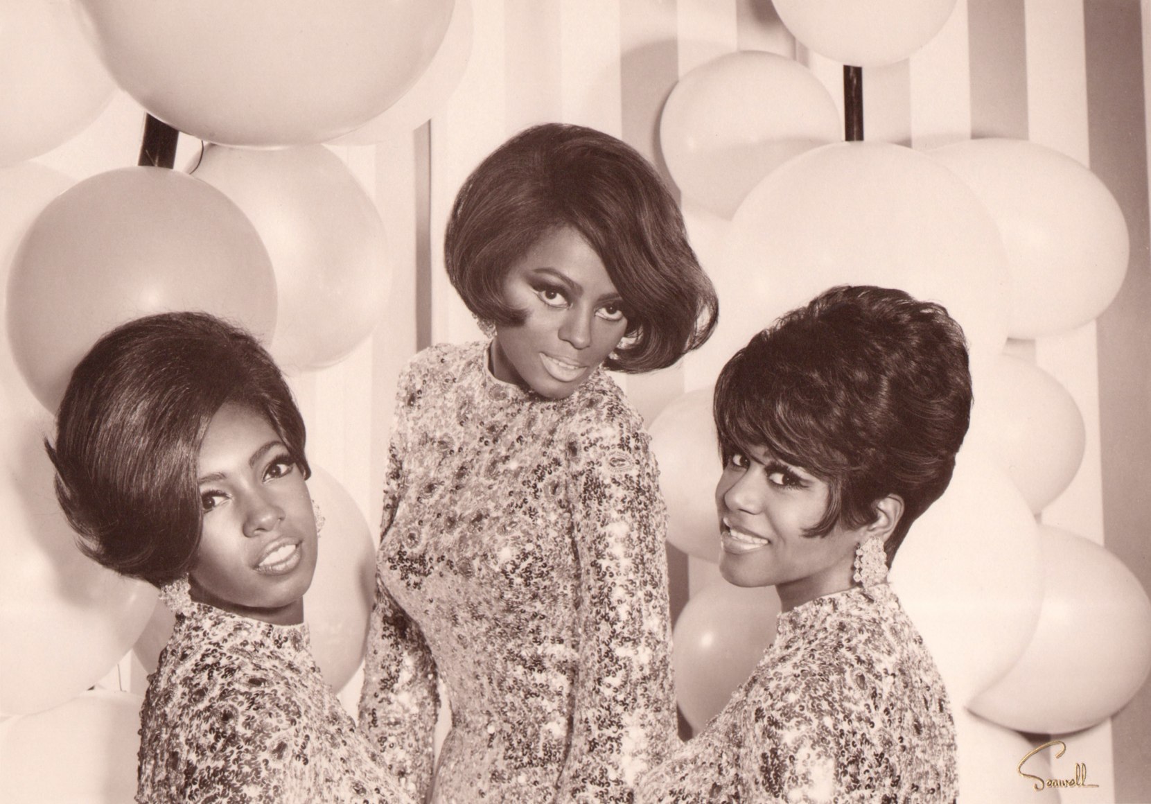 Wallace Seawell, Diana Ross &amp; The Supremes, ​1967. The three subjects pose in sparkling dresses against a striped wall with white balloons.