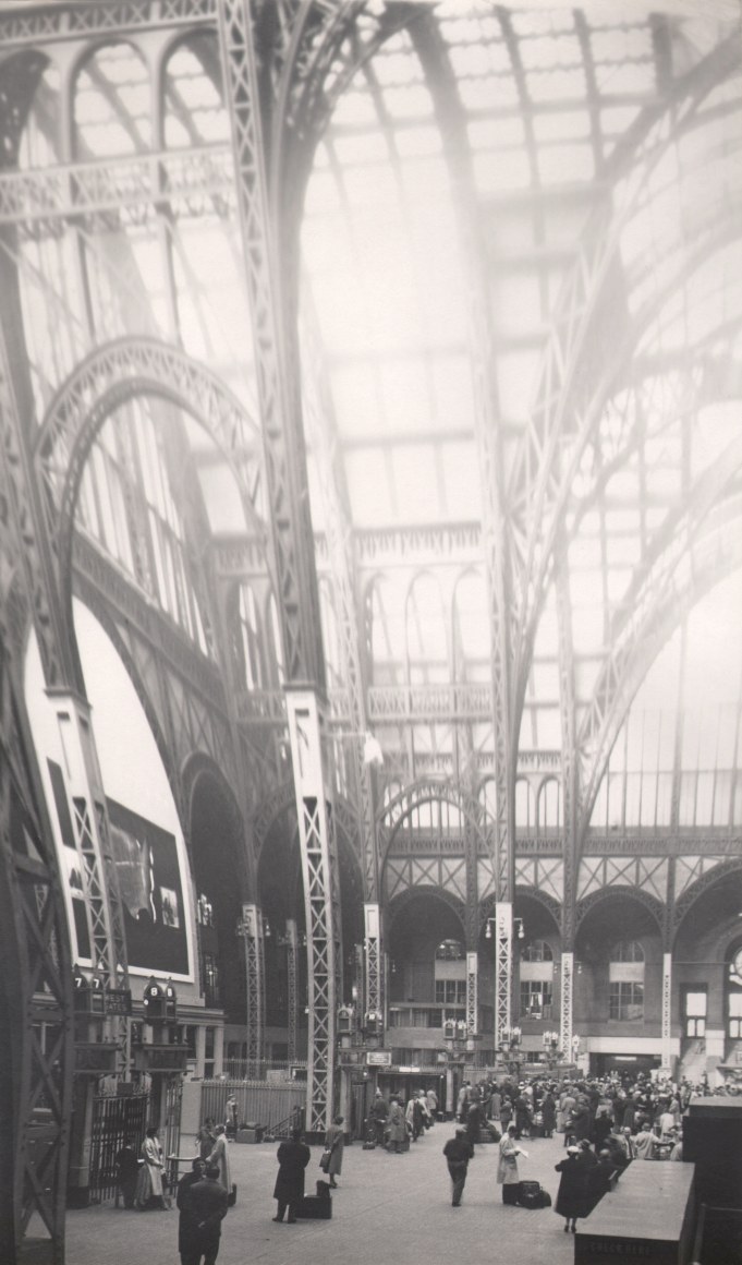 33. David Attie, Penn Station, ​1957. Vertically elongated image of the pillars and skylights of the original Penn Station building. Various commuters can be seen in the lower portion.