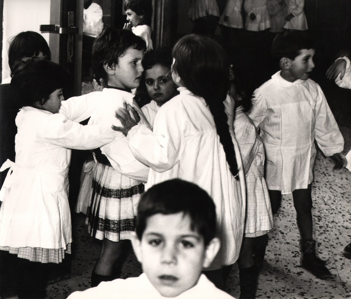 11. Renzo Tortelli, Piccolo Mondo, 1958&ndash;1959. High contrast image. A crowd of children in white gathered in a room.