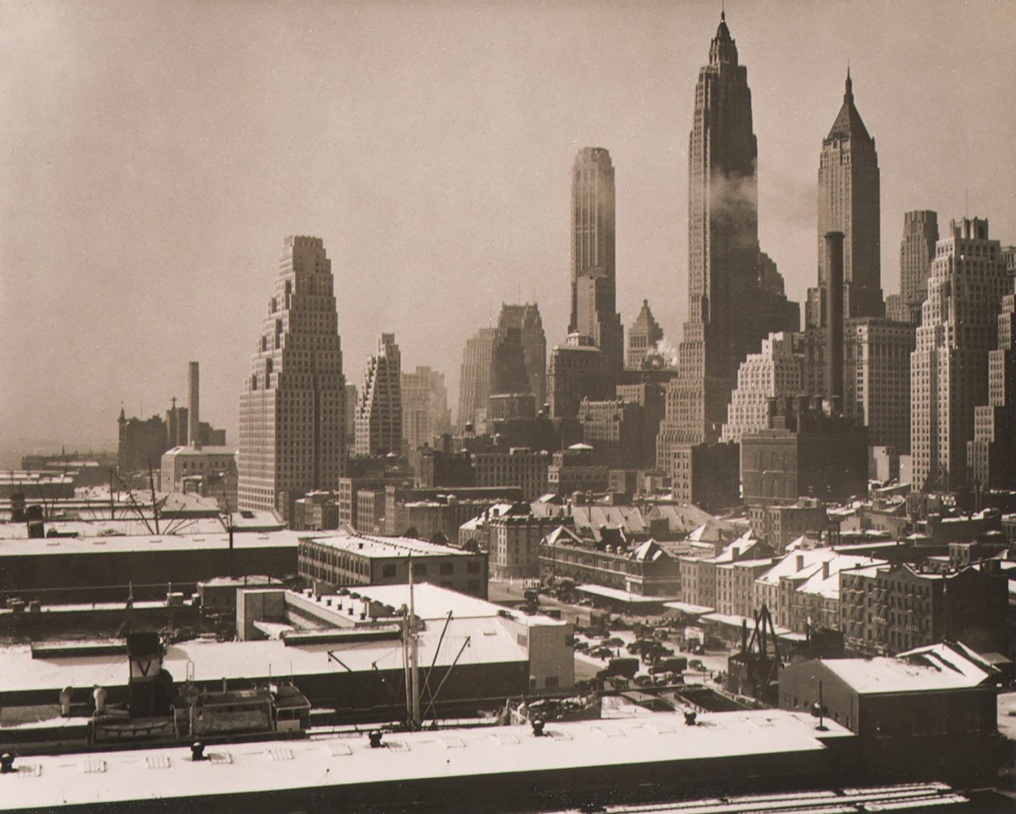 Paul J. Woolf, New York City Skyline, ​c. 1936. Day time cityscape with low buildings on the left and tall buildings on the right.