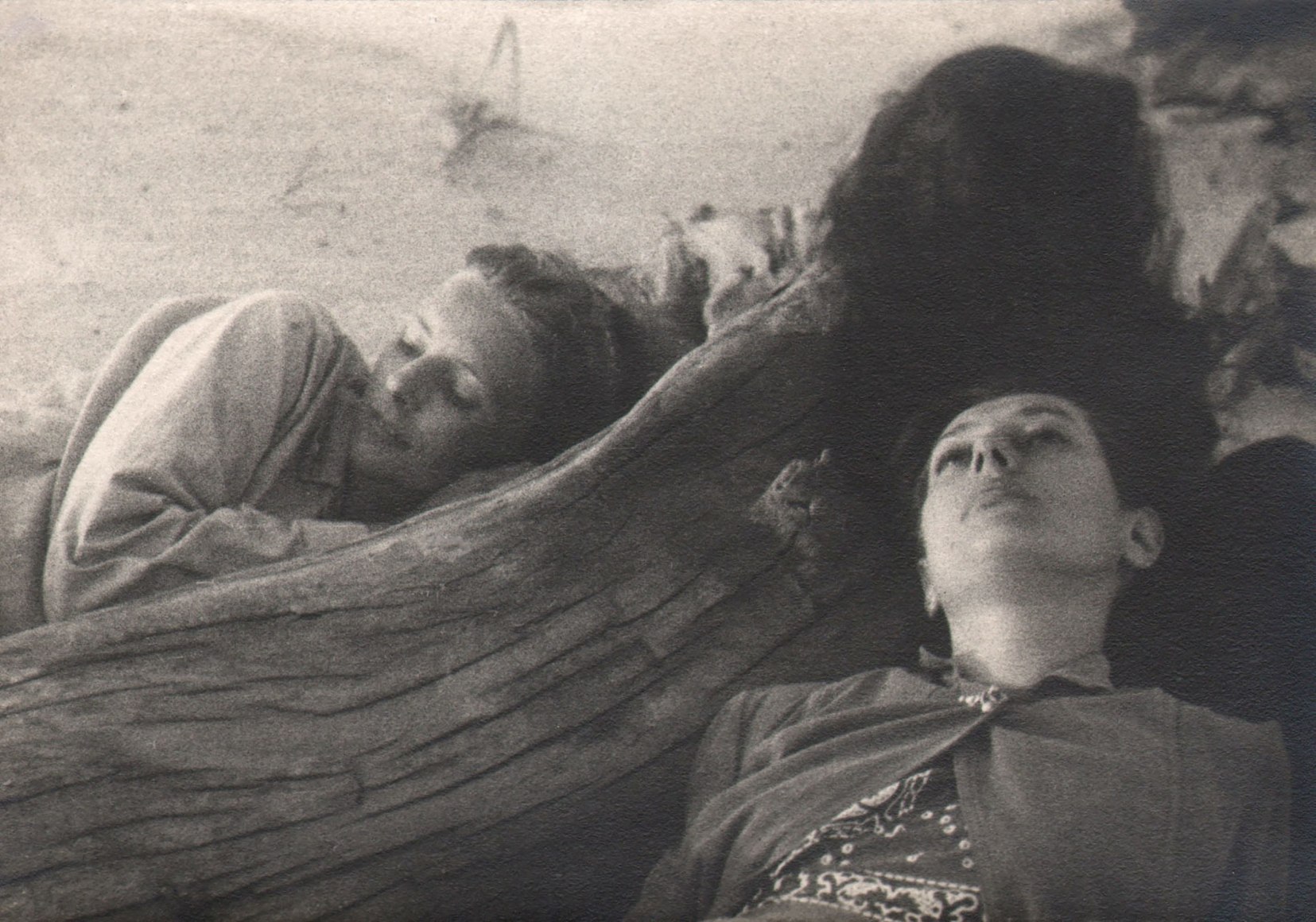 PaJaMa, Margaret French and Fidelma Cadmus, ​1942. Two women lay on the beach on either side of a piece of driftwood.