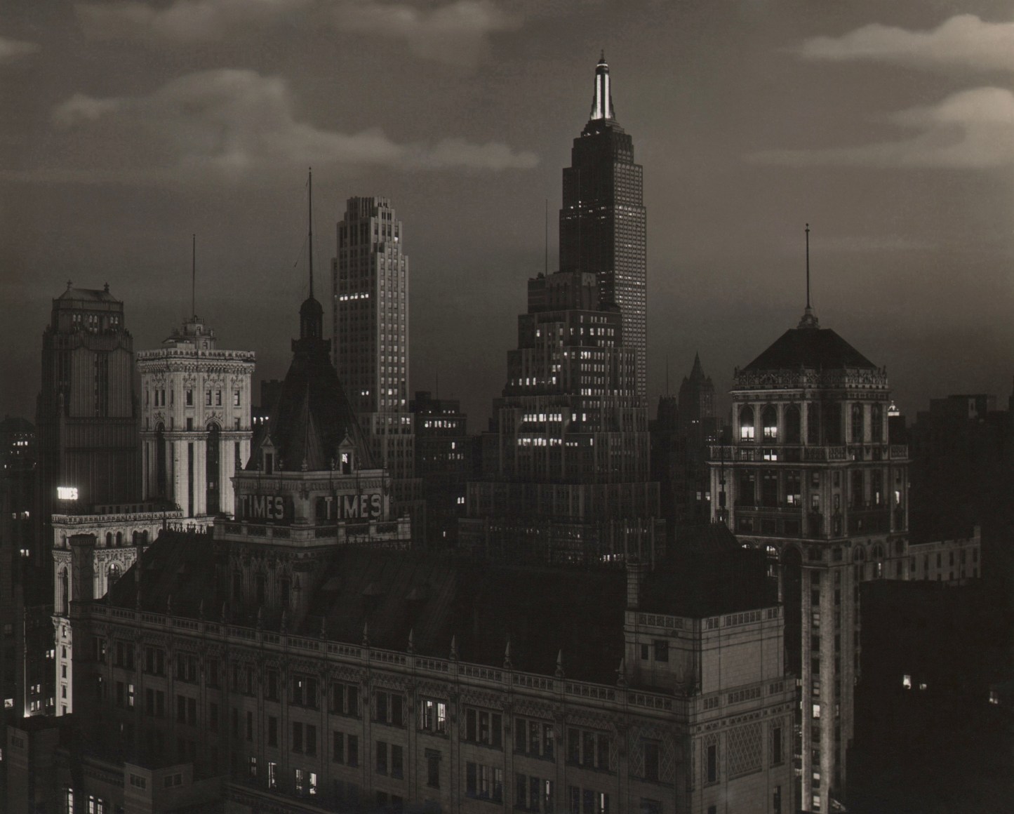 Paul J. Woolf, Times Building Looking South, ​c. 1935. Night time cityscape with partly cloudy skies.