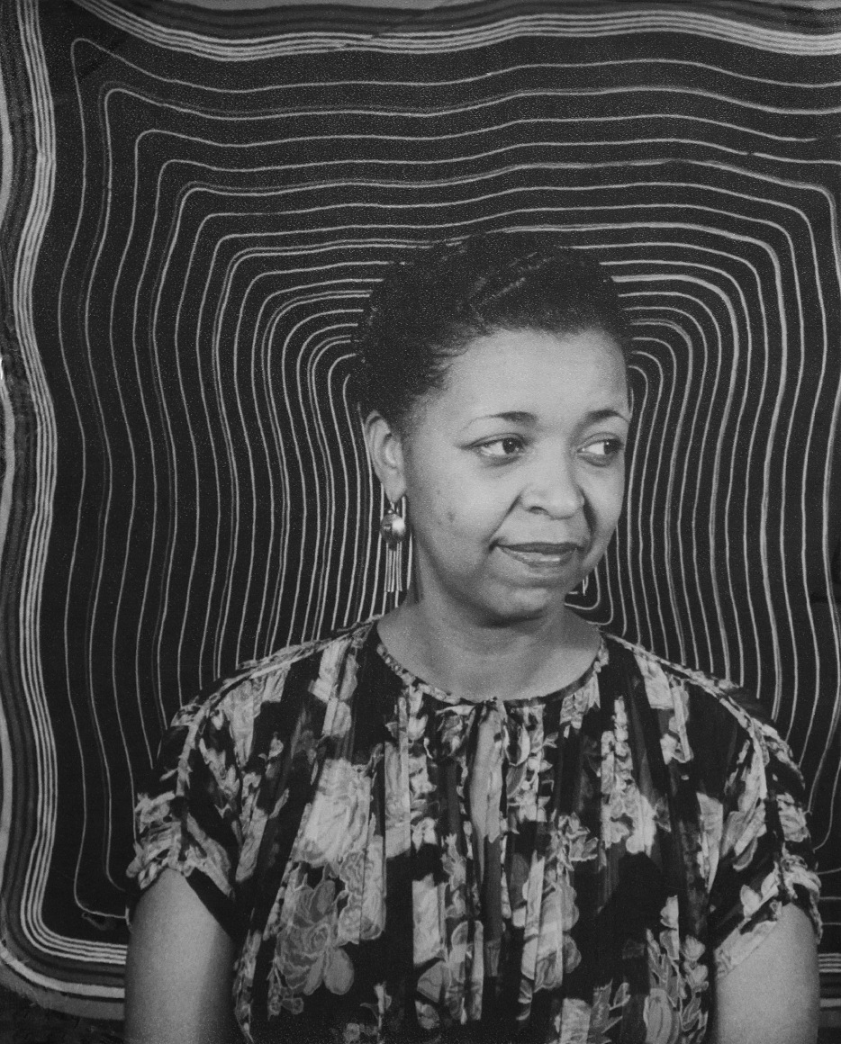 38. Carl Van Vechten, Ethel Waters, ​1938. Bust-length portrait with subject looking to the left of the frame against a backdrop of concentric wavy rectangles.