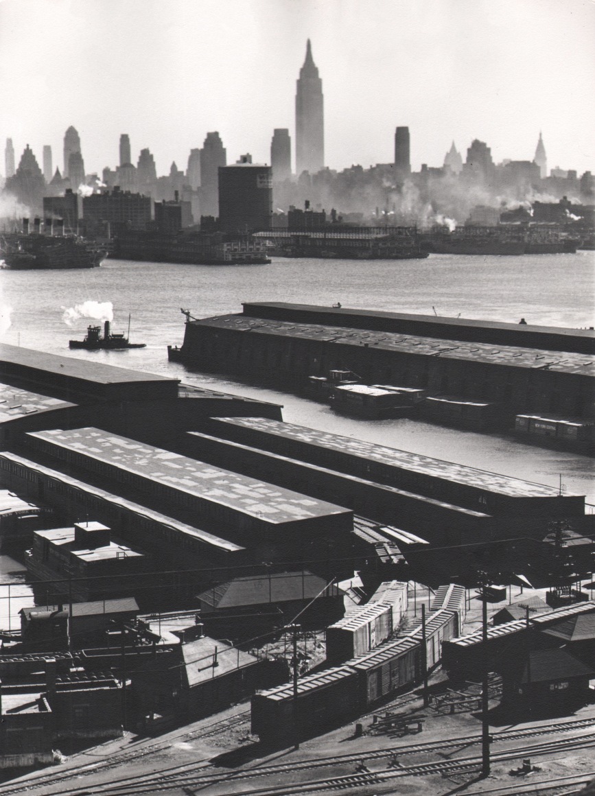 36. Esther Bubley, Weehawken, New Jersey. View looking east from 50th Street and East Boulevard showing New York Central piers, Hudson River and Midtown Manhattan skyline, 1946.