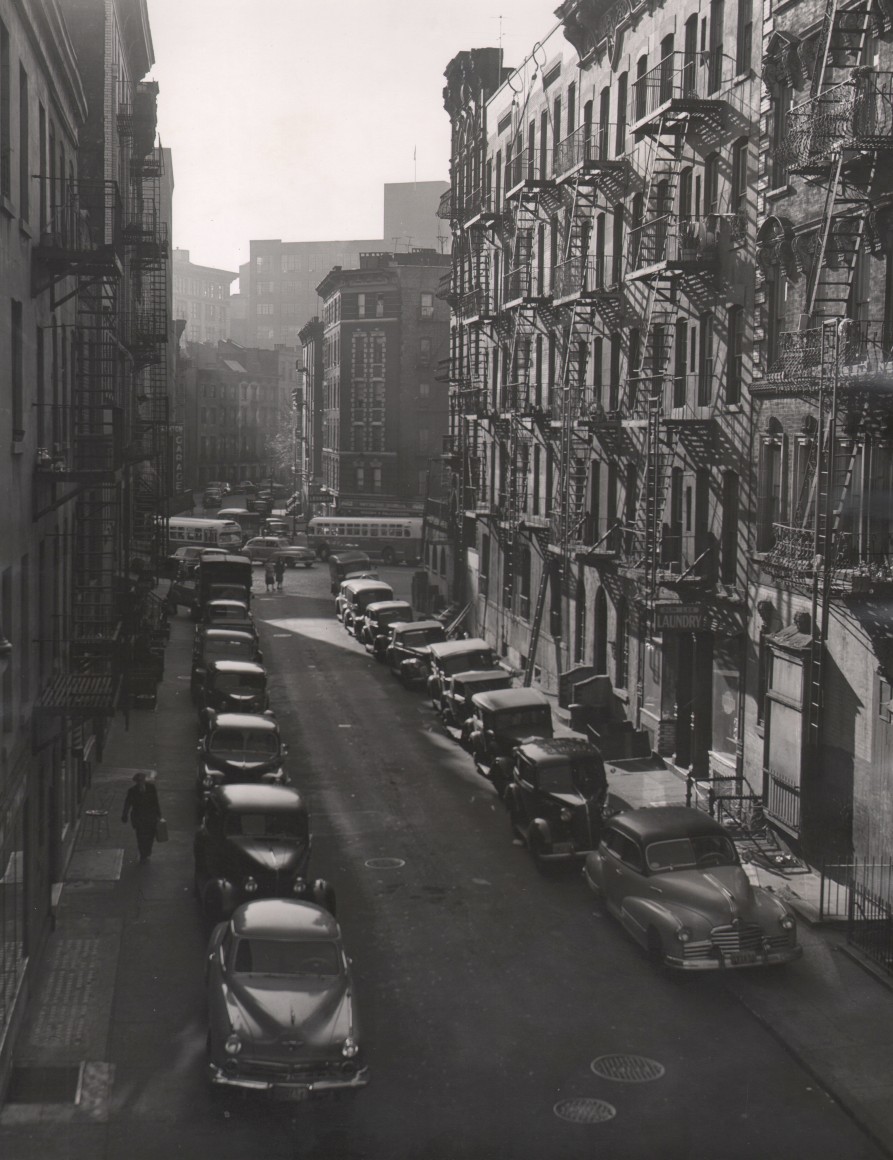 32. Charlotte Brooks, Cornelia Street, c. 1943. Street view from an elevated perspective; cars line both sides of the street.