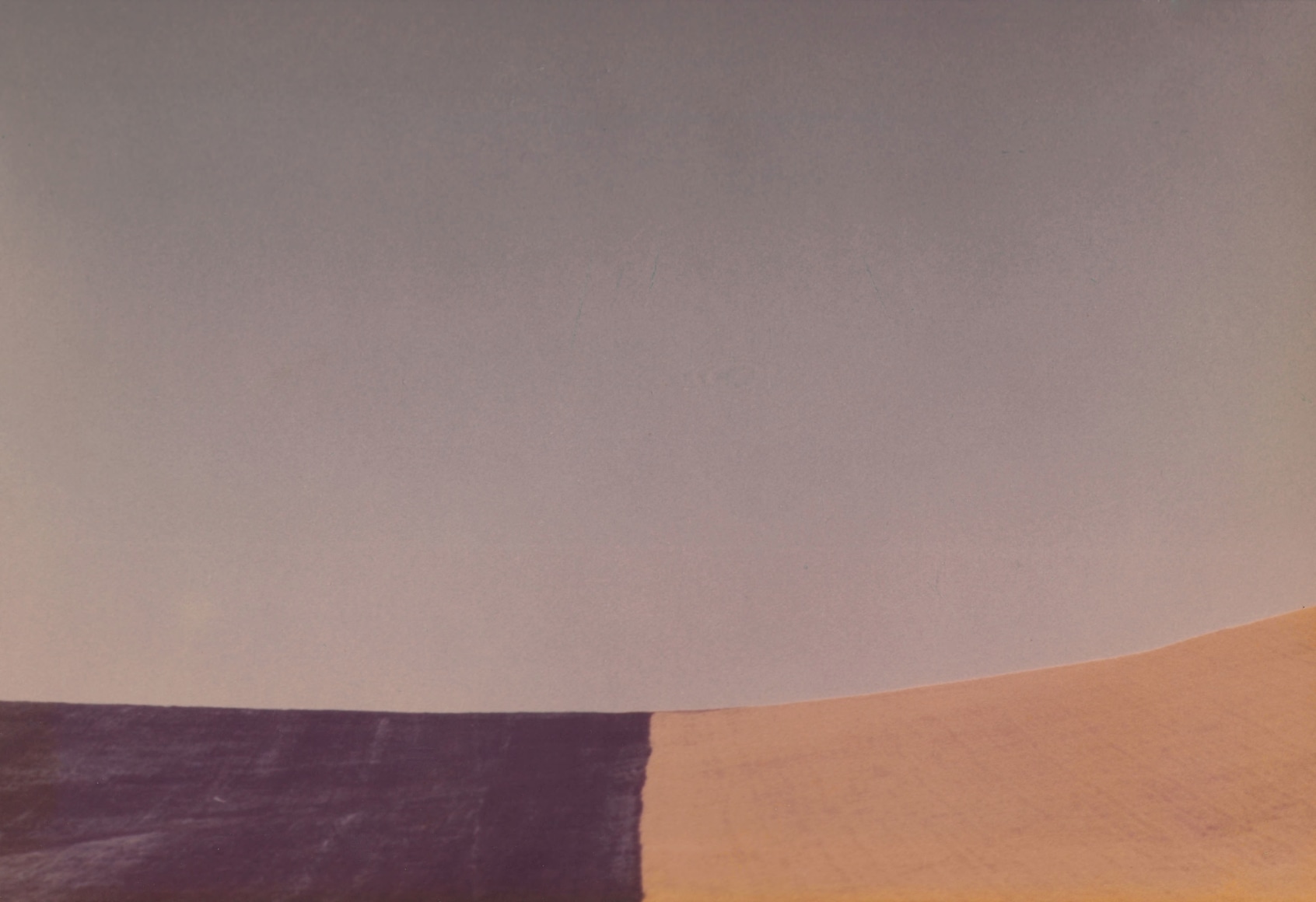 Franco Fontana, Untitled, ​1975. Abstracted color scene divided into three rectangles: the largest, a grayish purple, fills the majority of the frame, while the lower third is divided into two color fields of deep purple and yellow.