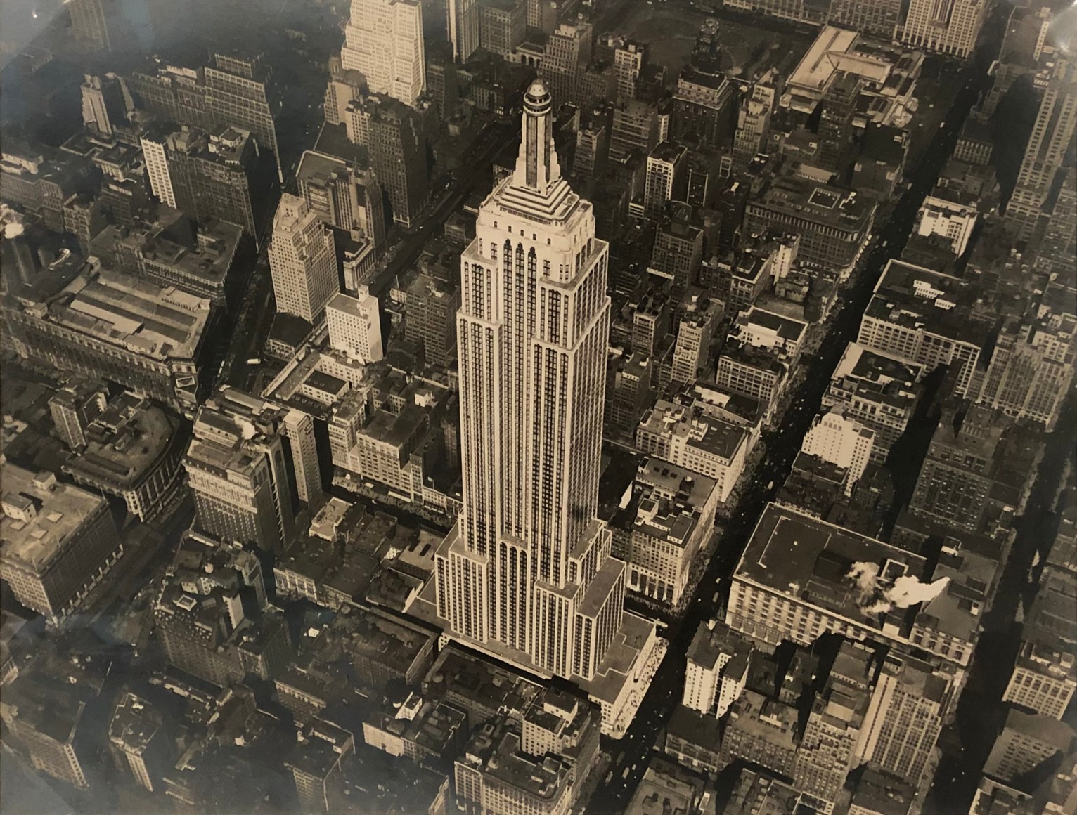23. Fairchild Aerial Surveys, Empire State Building, ​1931. Aerial view of the completed Empire State Building from above and to the right. The building occupies the center of the frame.