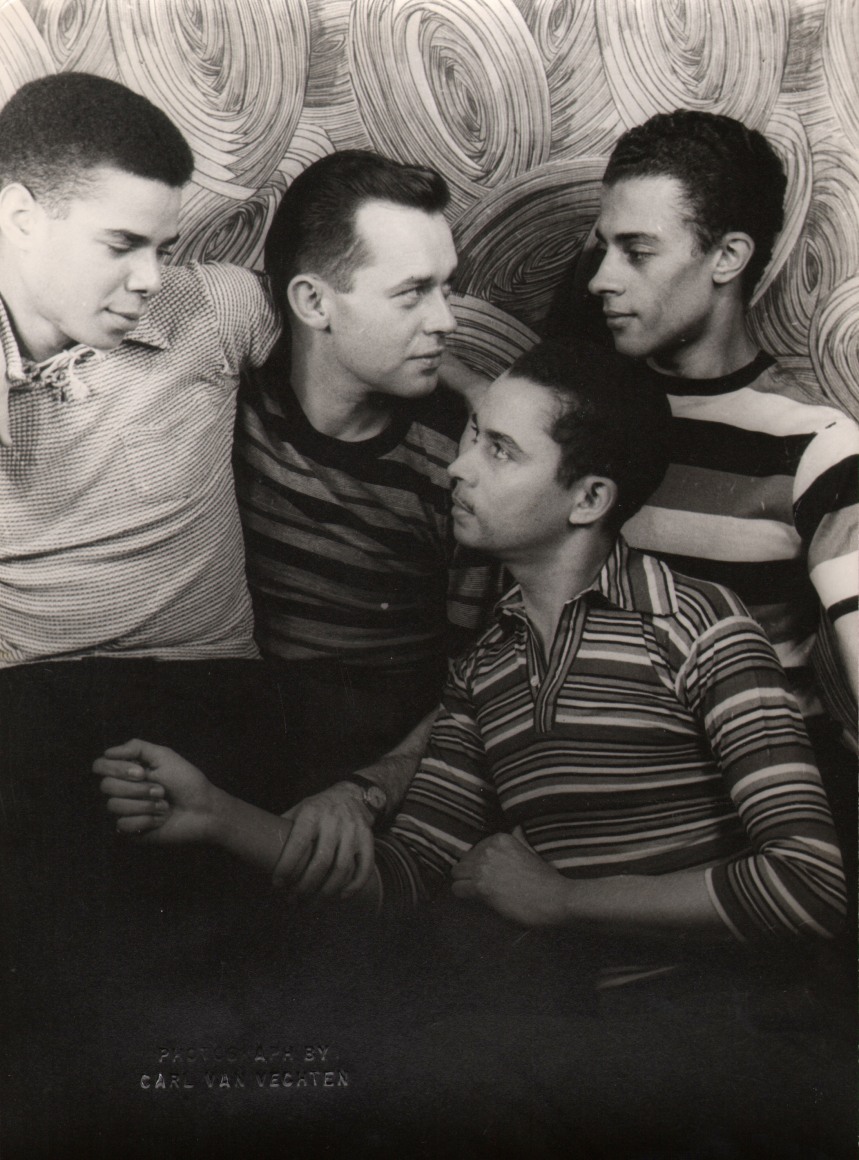 21. Carl Van Vechten, Frank Harriott, Karl Priebe, Edward Atkinson, Tom Kemp, 1948. Four men posing closely together and looking at one another against a backdrop with concentric circles.