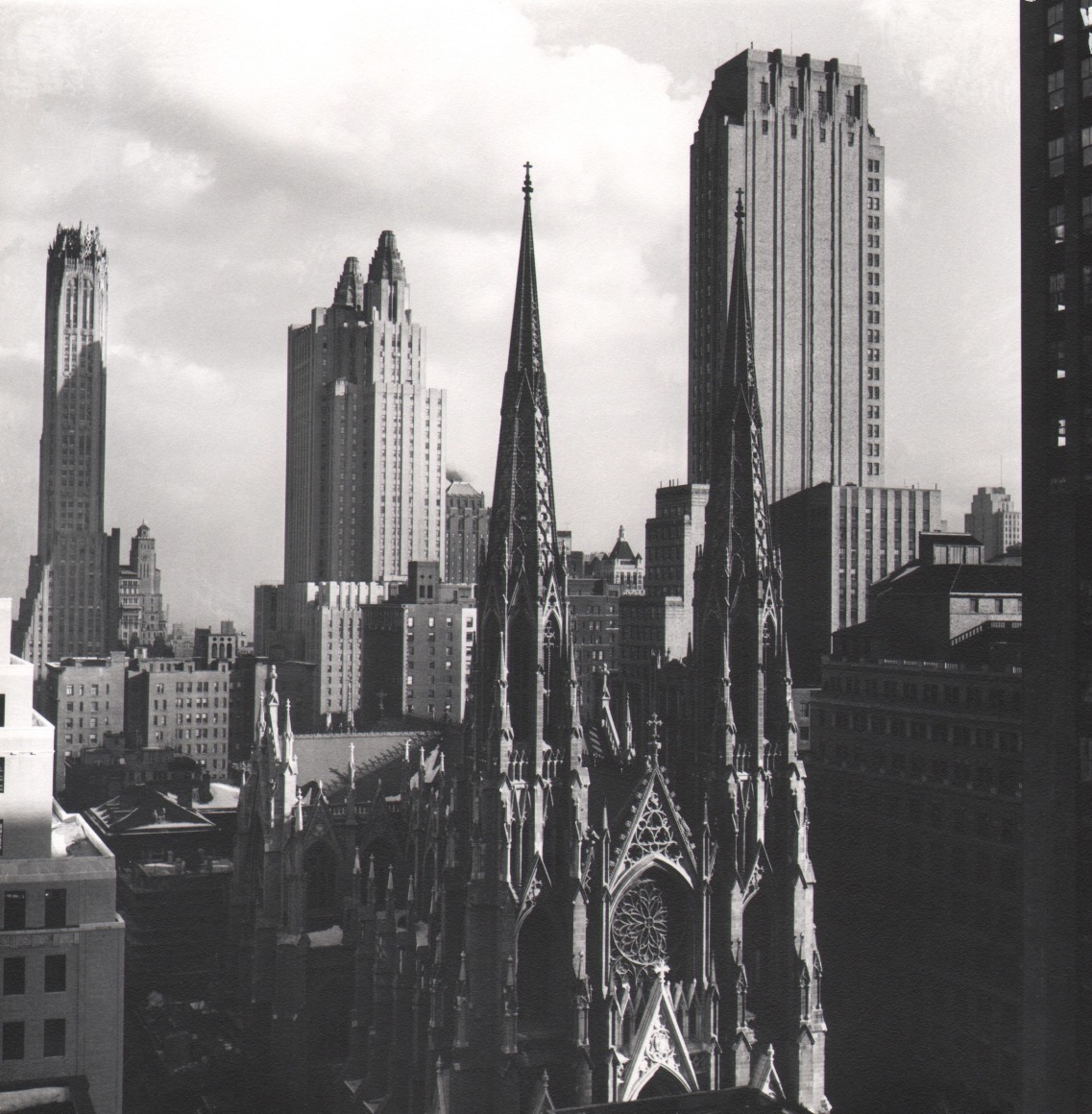 54. Todd Webb, View East from the 24th floor of the Esso Building, ​1947. Elevated view facing cathedral spires and nearby buildings in strong sunlight.