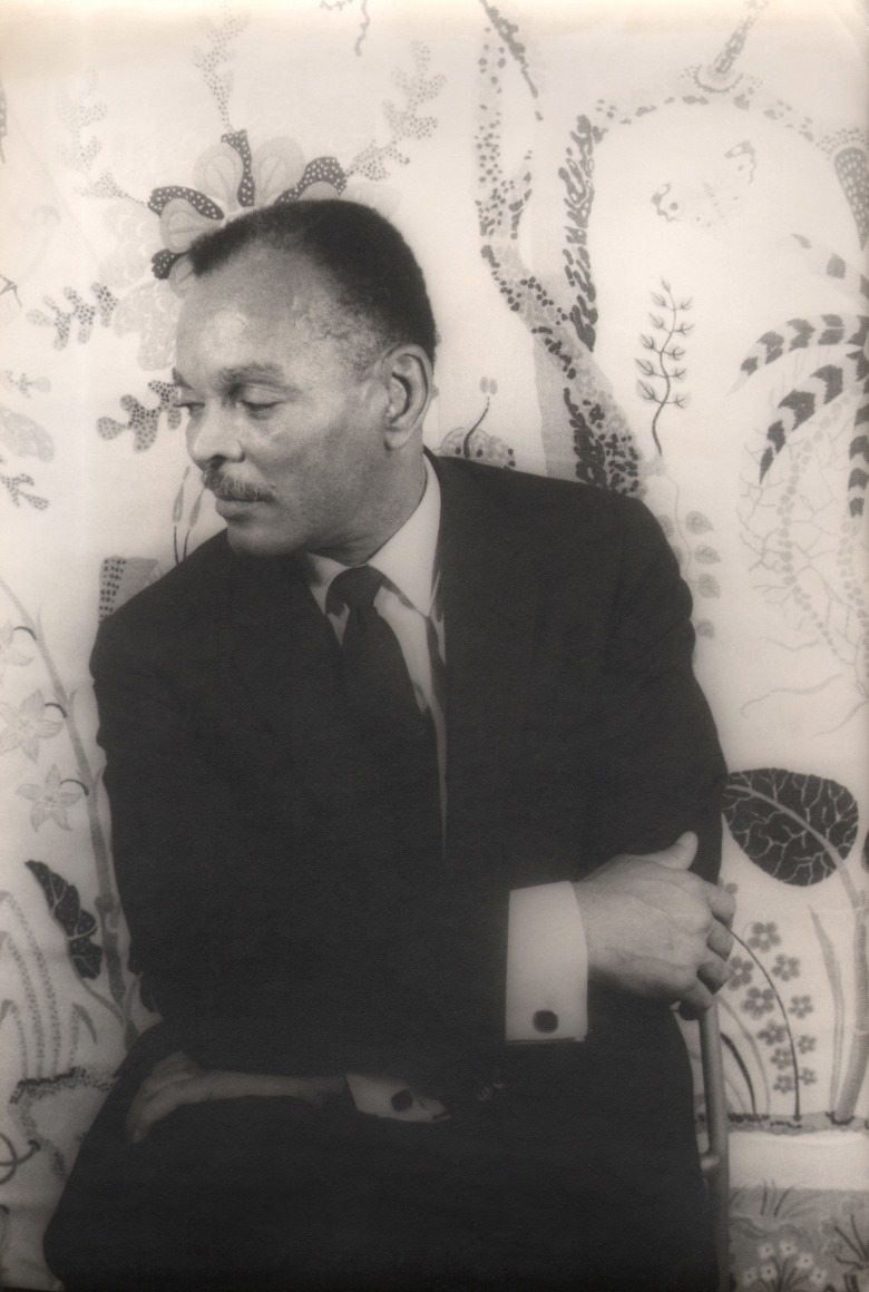 13. Carl Van Vechten, Chester Himes, ​1962. Seated portrait with subject's head facing the left of the frame, arms crossed in front of him.