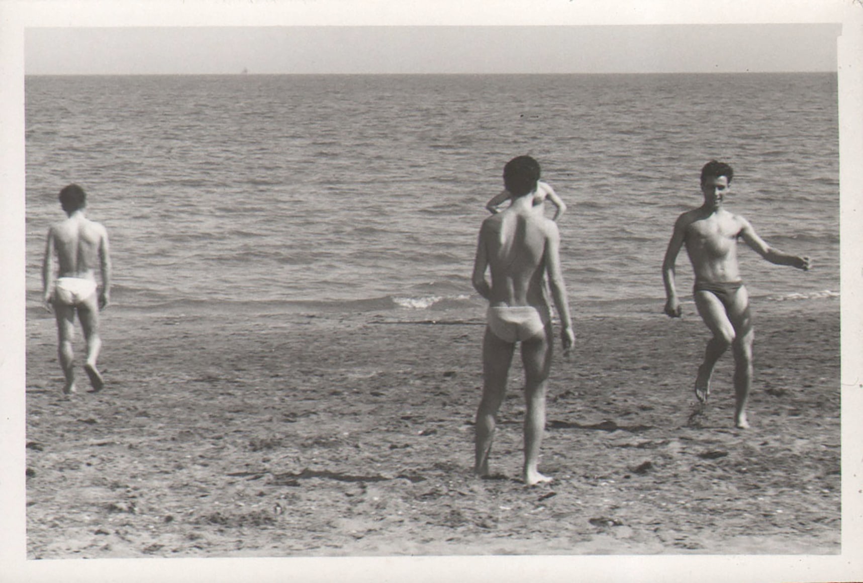 PaJaMa, Untitled, ​c. 1945. Four men in swimsuits stand on the beach. Two face the camera and two face away, towards the ocean.