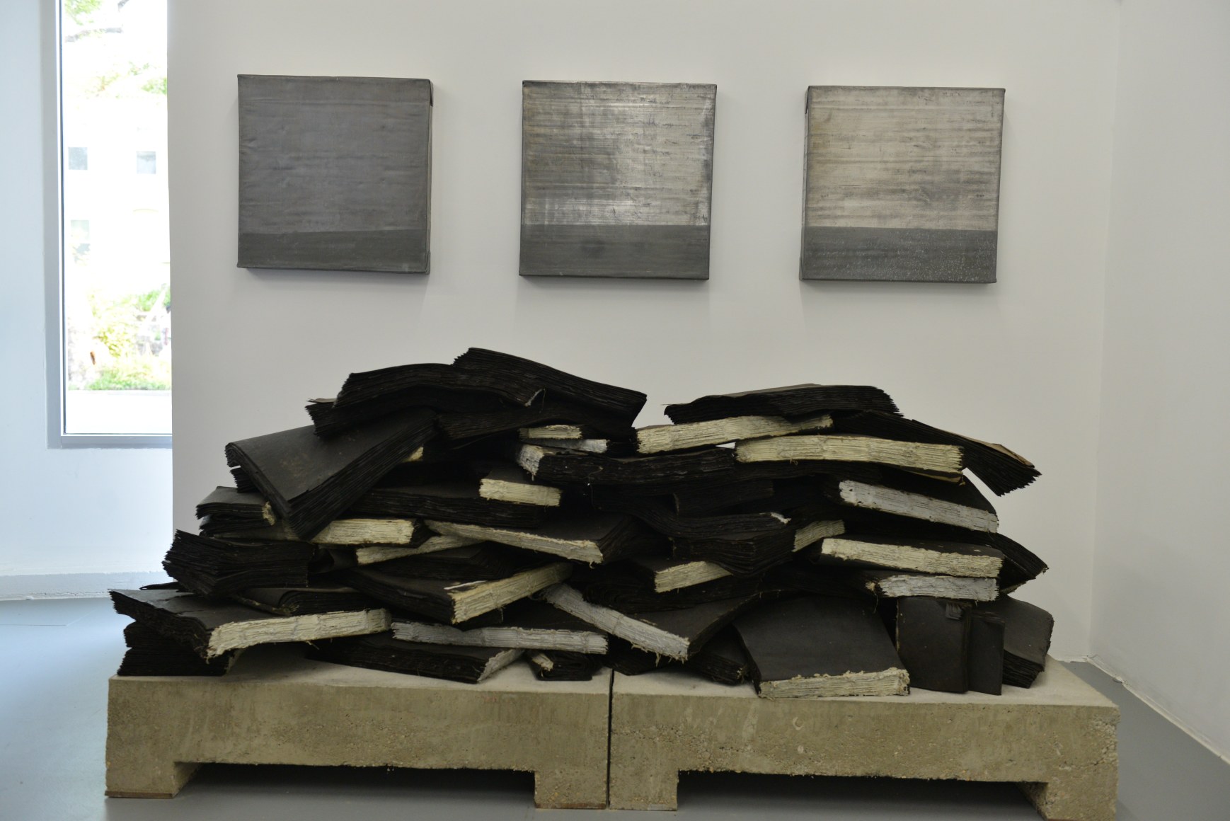 TRAVIS J. WAGNER Ta Biblia 2014, tar paper, twine, adhesive, concrete and steel, 33 x 88 x 40 inches. Installation view: CONNERSMITH.