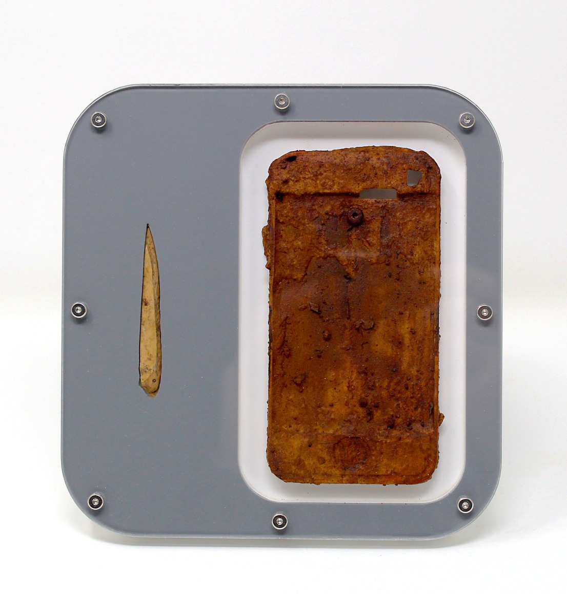 Benjamin Kelley  Untitled 04  2019, Iphone chassis and Iron Oxide, ancient bone tool, acrylic, stainless steel hardware, 6.25 x 6 x 1 inches.