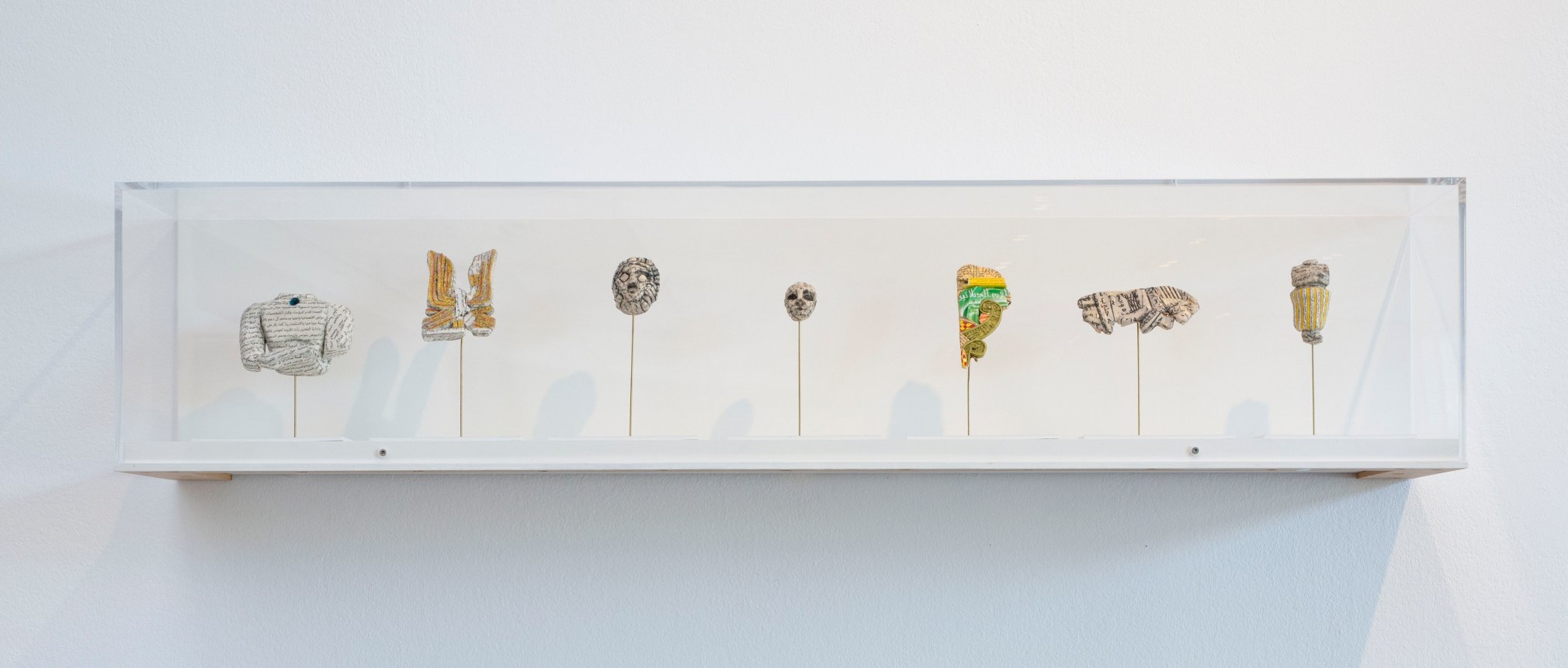 Michael Rakowitz, The invisible enemy should not exist, 2007 - ongoing, Wall-mounted vitrine with perspex cover; 7 objects from found Middle Eastern packaging and newspapers, glue, museum labels, 23 x 110 x 23 cm