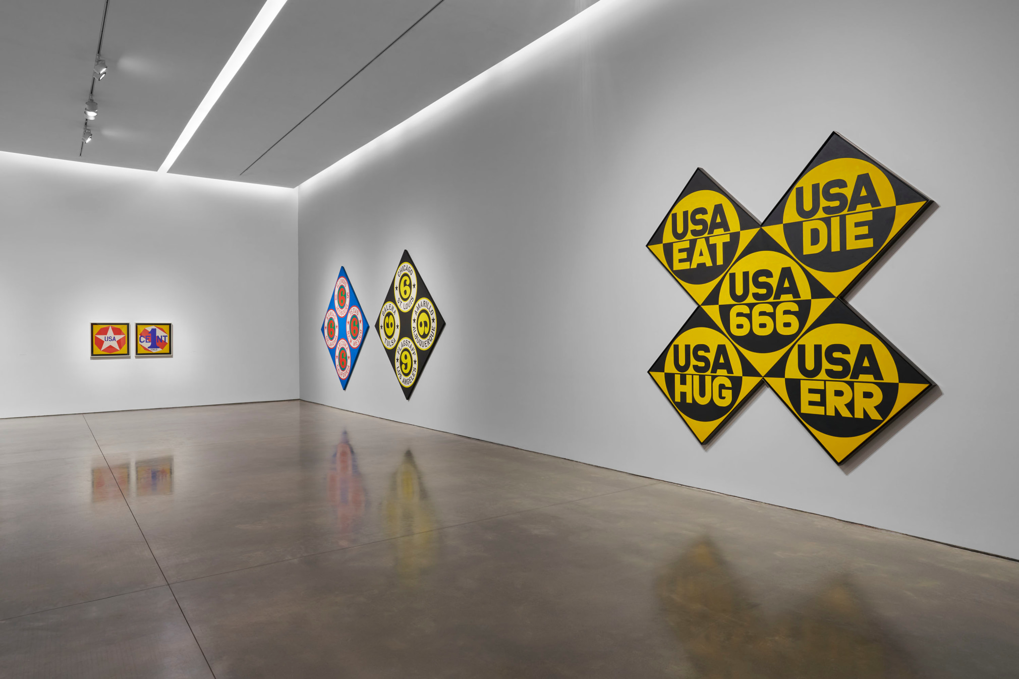 Installation view, Robert Indiana: The American Dream, Pace Gallery, New York, May 9&ndash;August 15, 2025. Left to right, New Glory Penny (1963),&nbsp;US 66 (States)/US 66 (Cities) (2002), and&nbsp;USA 666 (The Sixth American Dream) (1964&ndash;66)