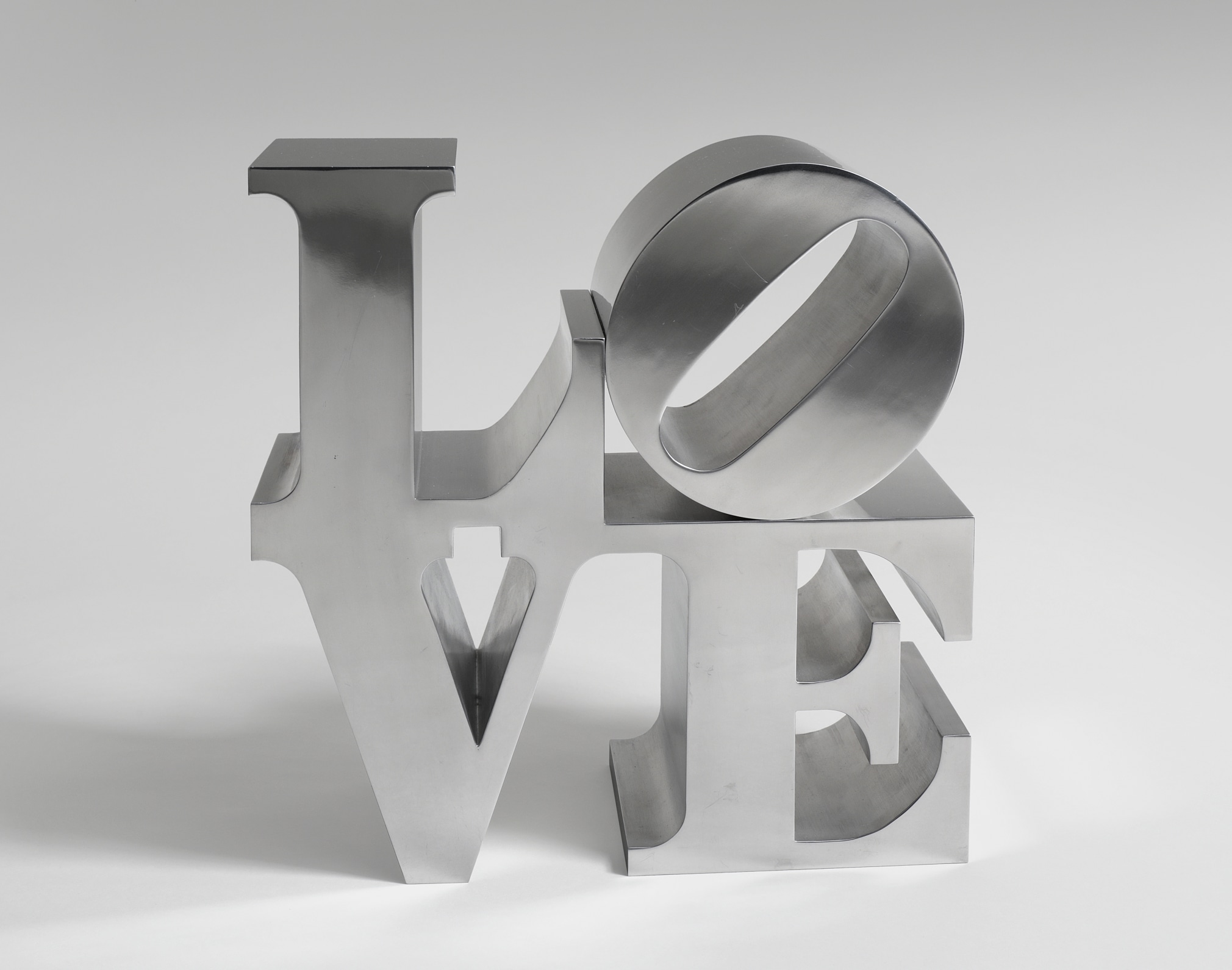 A 12 by 12 by 6 inch hand-cut and mirror-finished aluminum sculpture spelling love, consisting the letters L and a tilted letter O on top of the letters V and E.