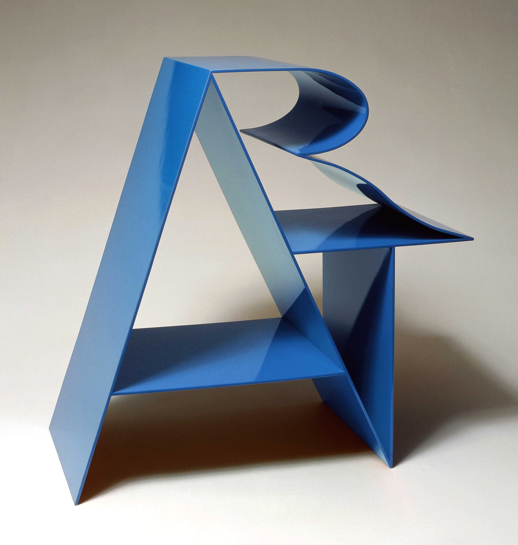 Art, an 18 by 18 by 9 inch blue polychrome aluminum sculpture. The letter &quot;A&rdquo; forms a supporting structure that the &ldquo;R&rdquo; and &ldquo;T&rdquo; lean against.