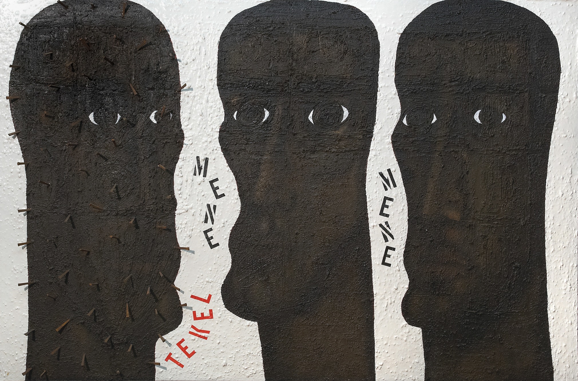 Mene Mene Tekel, a painting comprised of three dark brown totem like heads, the first has nails in it. In between the first two heads are the words Mene and Tekel; in between the second two heads is the word Mene