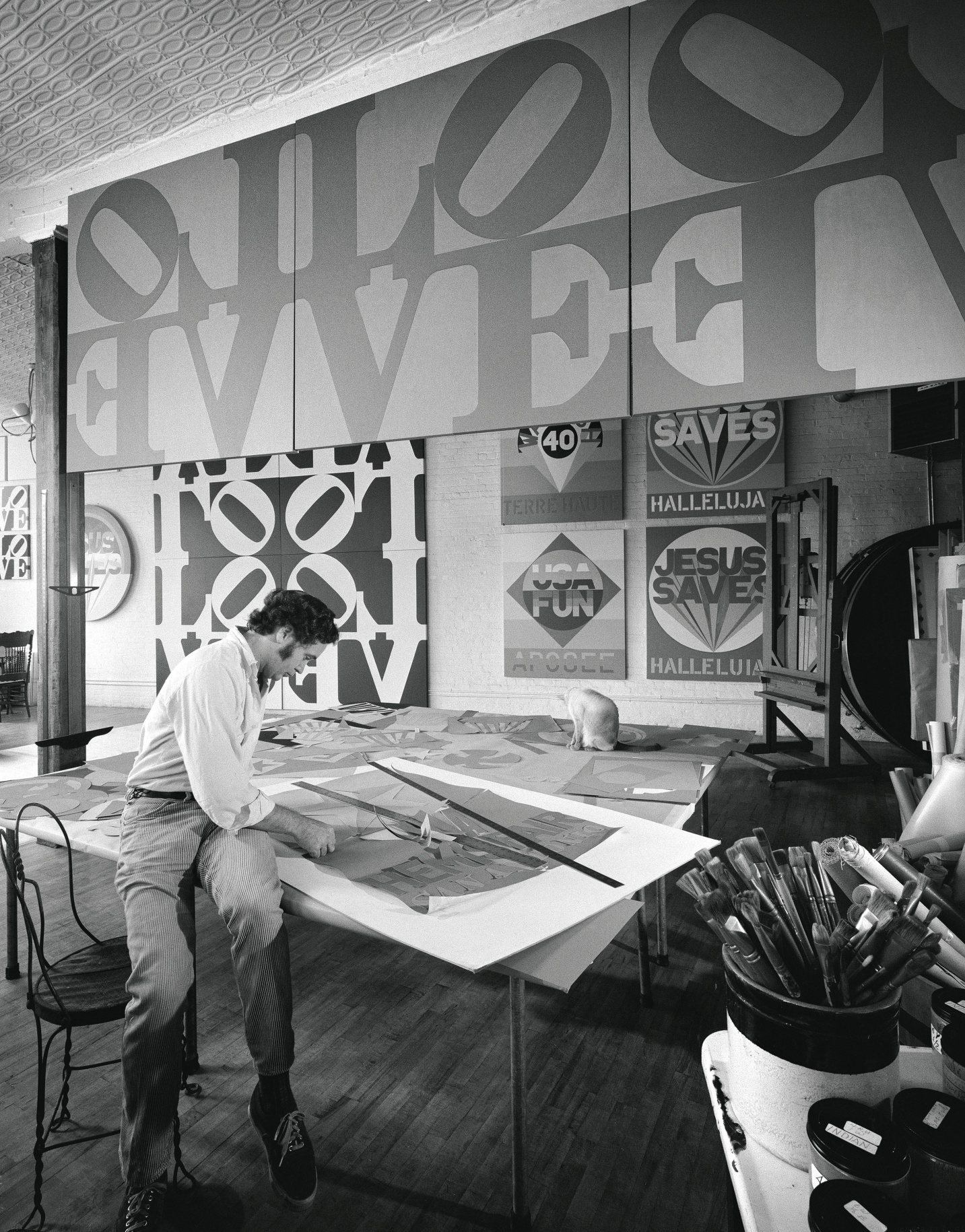 Indiana working in his studio. Halleluiah is visible on the back wall, lower right. To its left is Apogee (1970).&nbsp;Photo: Hans Namuth. Courtesy Center for Creative Photography, University of Arizona &copy; 1991 Hans Namuth Estate