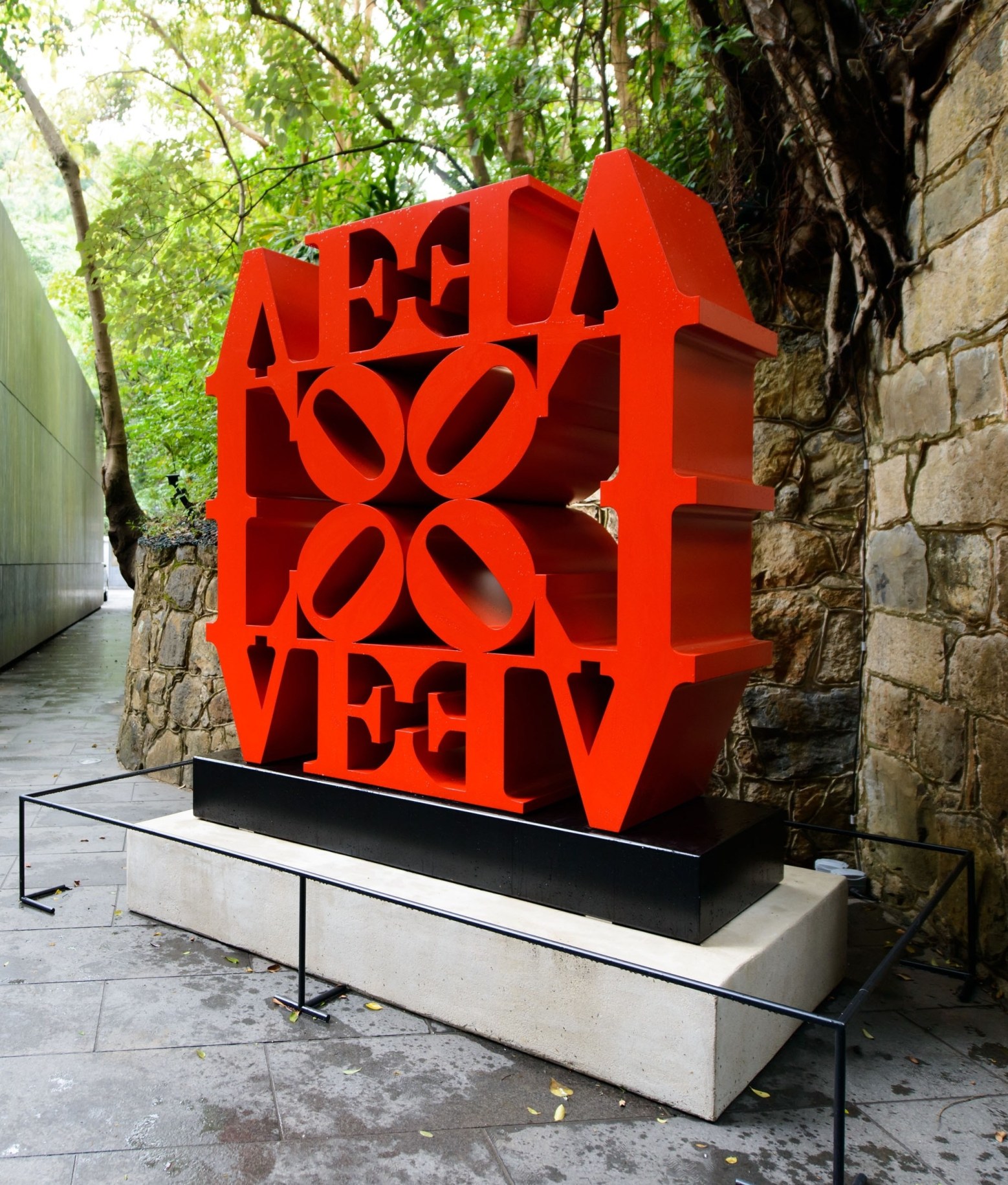 LOVE Wall, a 72 by 72 by 24 inch red polychrome aluminum sculpture consisting of four LOVEs, each with the letters L and a tilted O above the letters V and E. , Two of the LOVEs are upright and two inverted, all facing inward with the four &ldquo;O&rdquo;s meeting in the center.