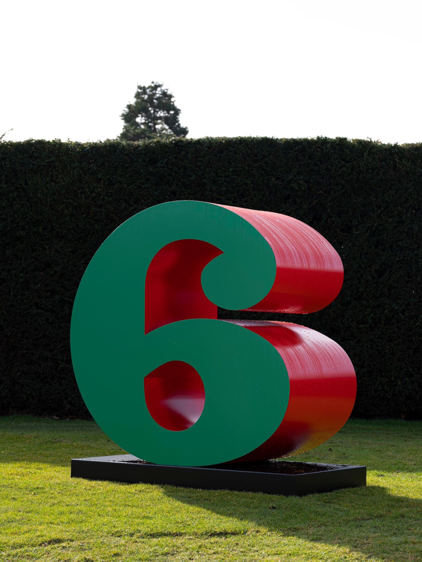 Installation view of Indiana's green and red polychrome aluminum sculpture of the number SIX at Yorkshire Sculpture Park
