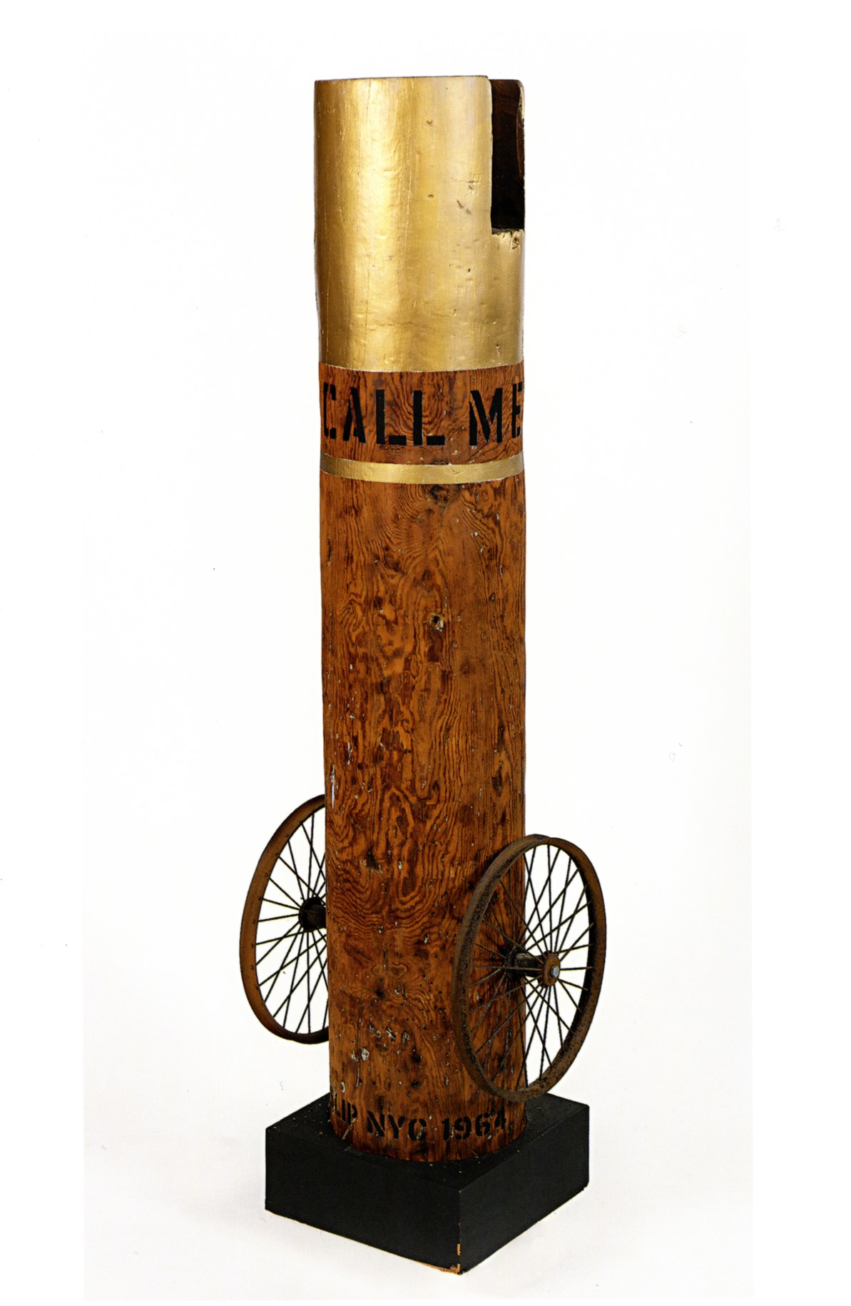 A 63 5/8 by 17 by 14 inch column with an iron wheel on the bottom left and right of the sculpture, and standing on a wooden base. The top of the column is gold, below, in black letters wrapping around the column, is its title, &quot;Call Me Indiana.&quot; Below the title, wrapping around the column, is a gold stripe.