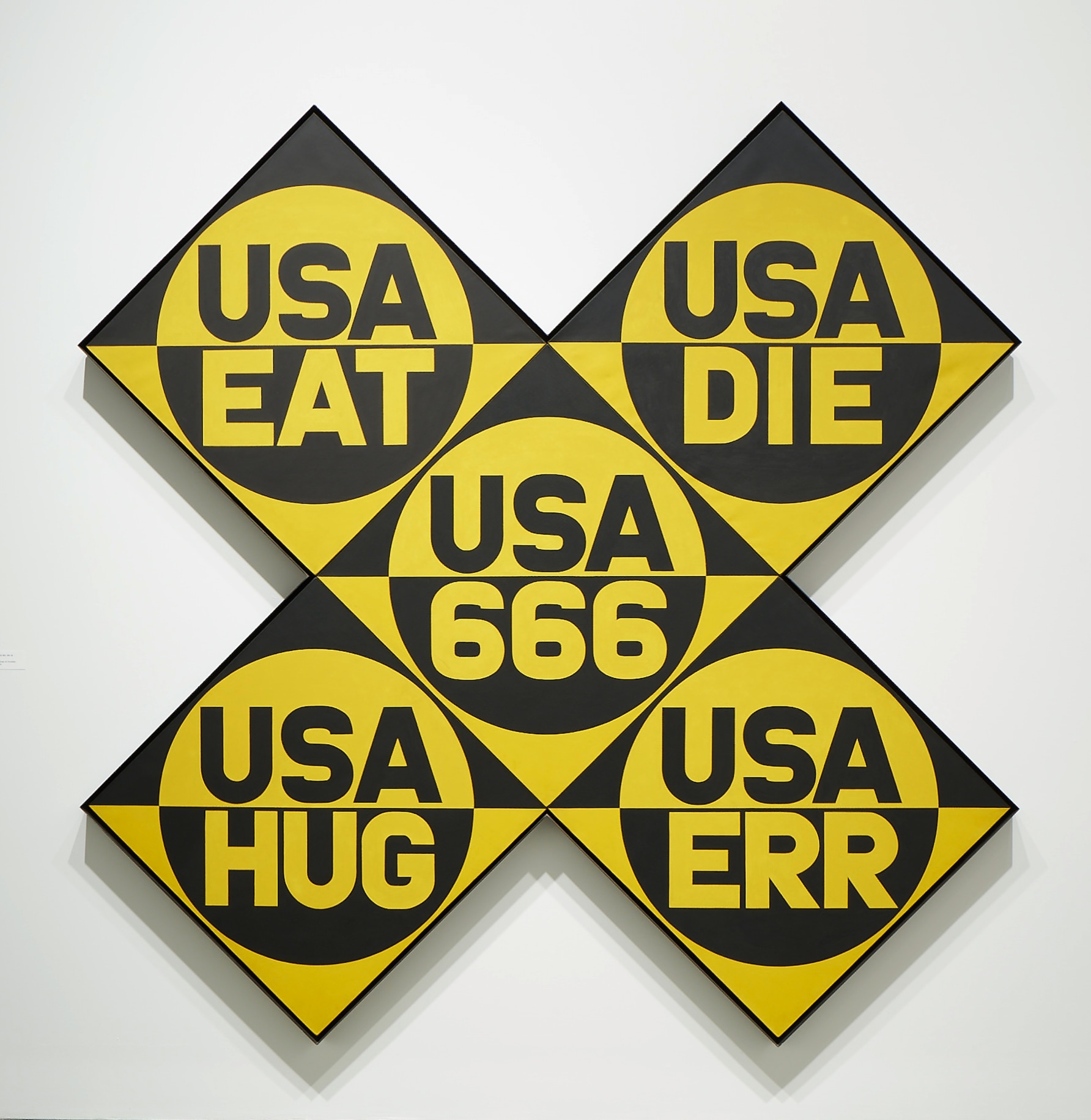 USA 666 (The Sixth American Dream)  is a yellow and black x-format painting, made up of five panels and measuring 102 by 102 inches overall. Each panel has a circle divided in two, the top half yellow with USA painted in black, and the bottom black with a yellow word. The words are, clockwise from top left, &quot;EAT,&quot;&quot;DIE,&quot; &quot;ERR,&quot; &quot;HUG,&quot; and in the central panel &quot;666.&quot;