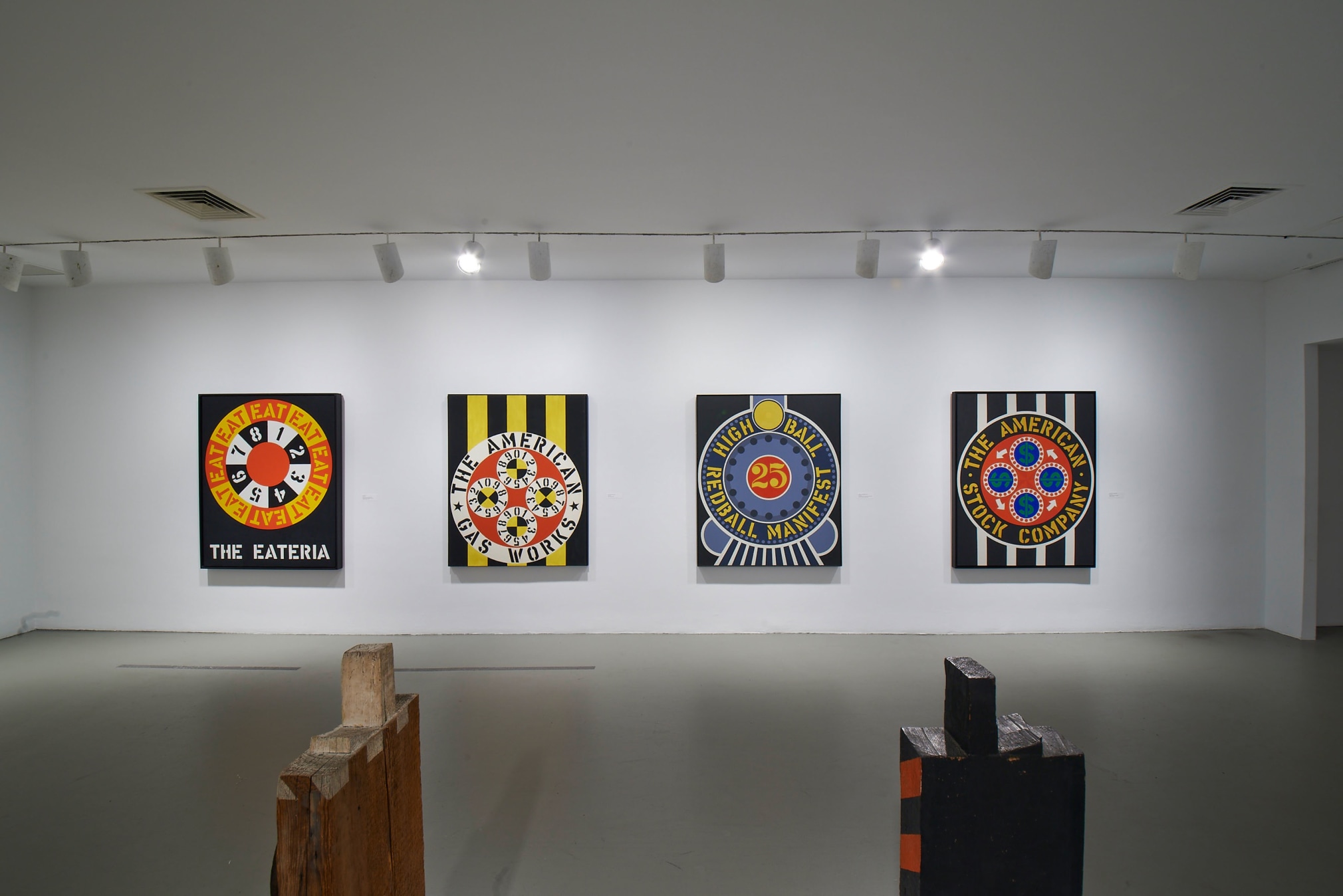 Installation view of Robert Indiana: Beyond LOVE, Whitney Museum of American Art, New York, September 26, 2013&ndash;January 5, 2014. Left to right, The Eateria (1962), The American Gas Works (1961&ndash;62), Highball on the Redball Manifest (1963), and The American Stock Company (1963), &nbsp;