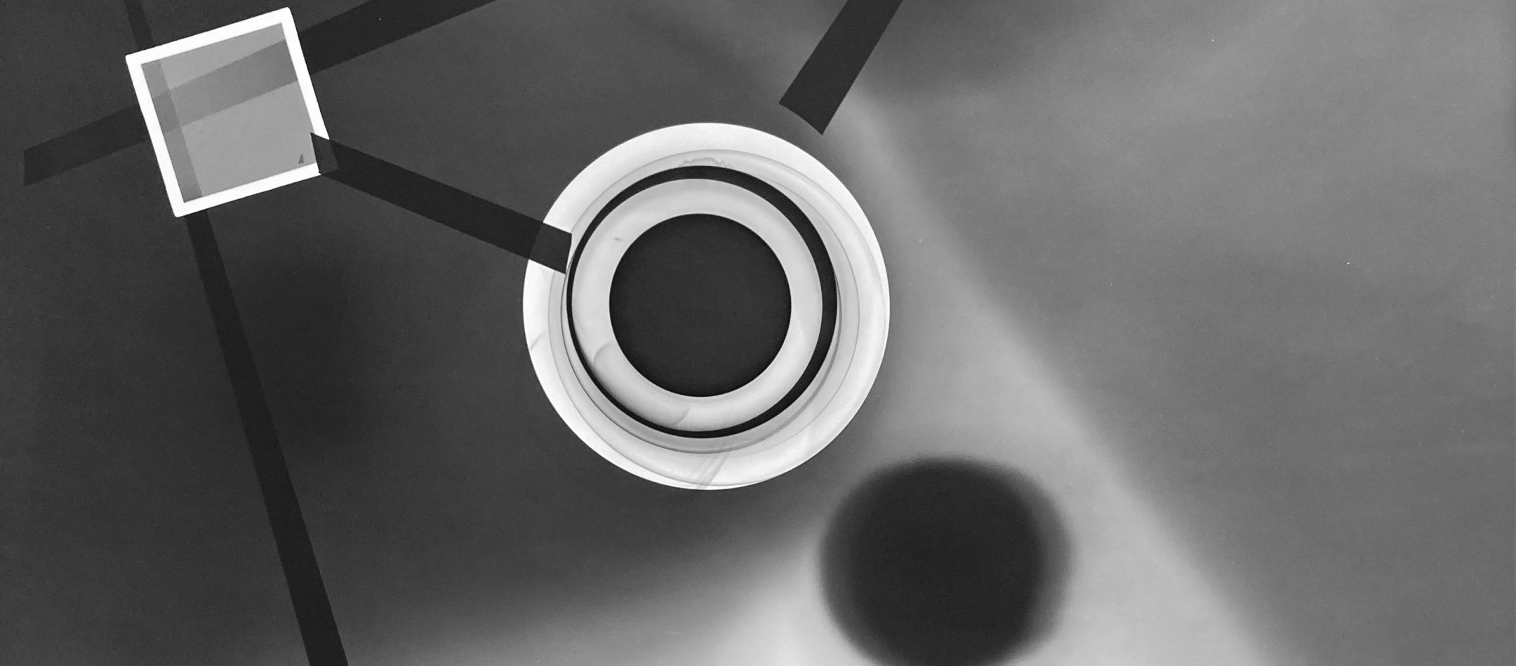 Black and white abstract photo print showing abstract composition made of brighter concentric circles and darker lines.