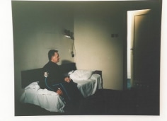 Security guard sitting on twin bed