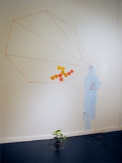 Yarn hung geometrically on gallery wall
