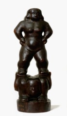 Dark wooden sculpture of two acrobat figures. One figure is lying down while the other figure stands on top of their legs. The standing figure is facing forward with their hands on their hips.