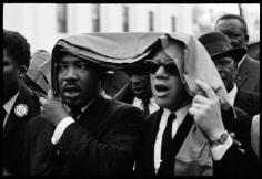 Dr. Martin Luther King, Jr. marches in the rain with a fellow clergyman, during the Selma to Montgomery Civil Rights March, 1965, Silver Gelatin Photograph
