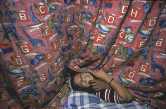 Kamla laughing with a customer, peeks out from under her alphabet curtain, Bombay, 1978, 12-1/4 x 18-3/4 Dye Transfer Photograph