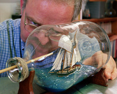 Man repairing ship-in-a-bottle, Newburyport, MA, 2002