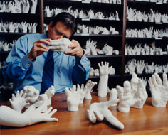Surgeon with molds of hands he has repaired, Brookline, MA, 2002