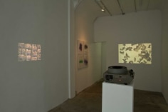 A photograph of the 2 video works thrown on the left wall and back wall
