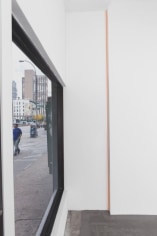 A photograph of the front window at left of the gallery and a grosgrain ribbon piece in orange (&quot;creamsicle&quot;) installed in the front corner of the gallery.