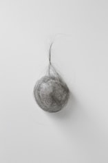 A silver ball made that resembles a hairball, hung on the wall